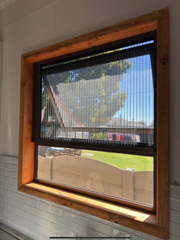 Insect screen installed in a wooden window frame.