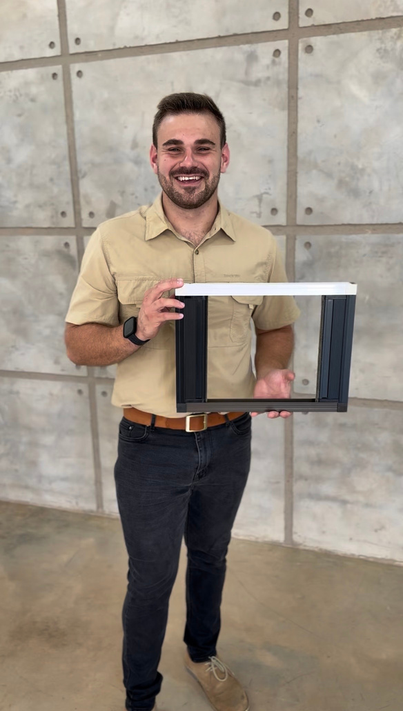 Danoptics installer holding a window screen frame.