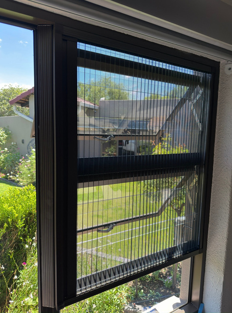 Window with a black pleated insect screen installed.